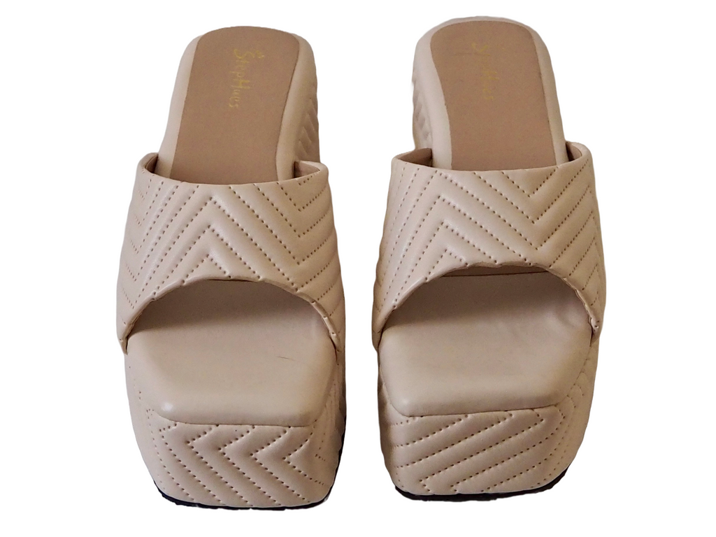 A pair of beige poolside wedges with a geometric pattern on the upper part.